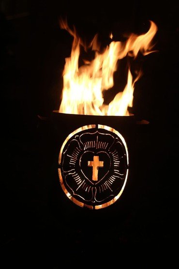 Brennende Feuerschale mit dem Symbol der Lutherrose.