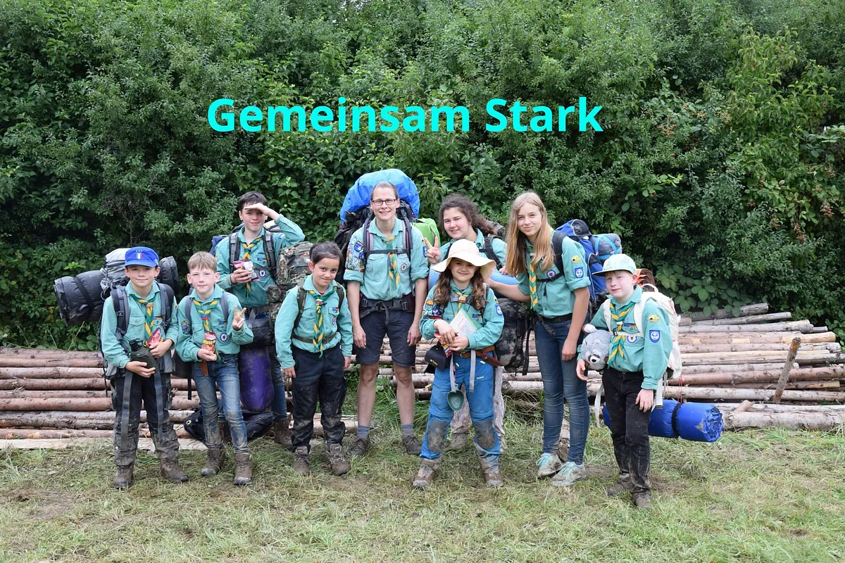 Gruppe von zehn schlammigen Pfadfindern mit Rucksäcken, "Gemeinsam Stark".