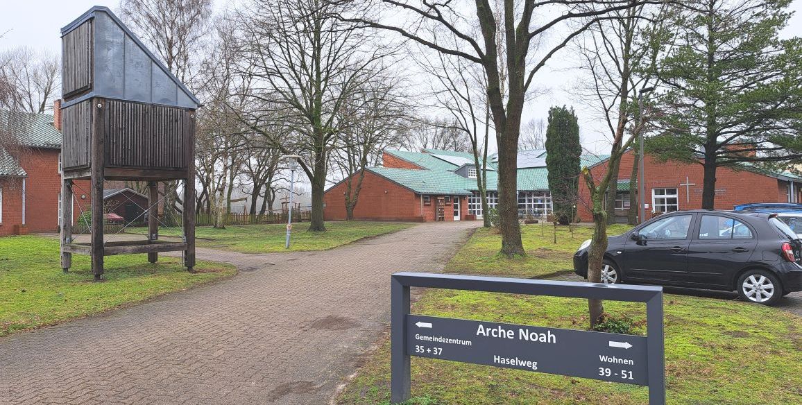 Gemeindezentrum Arche Noah mit Schild, Kirche und Parkplatz.